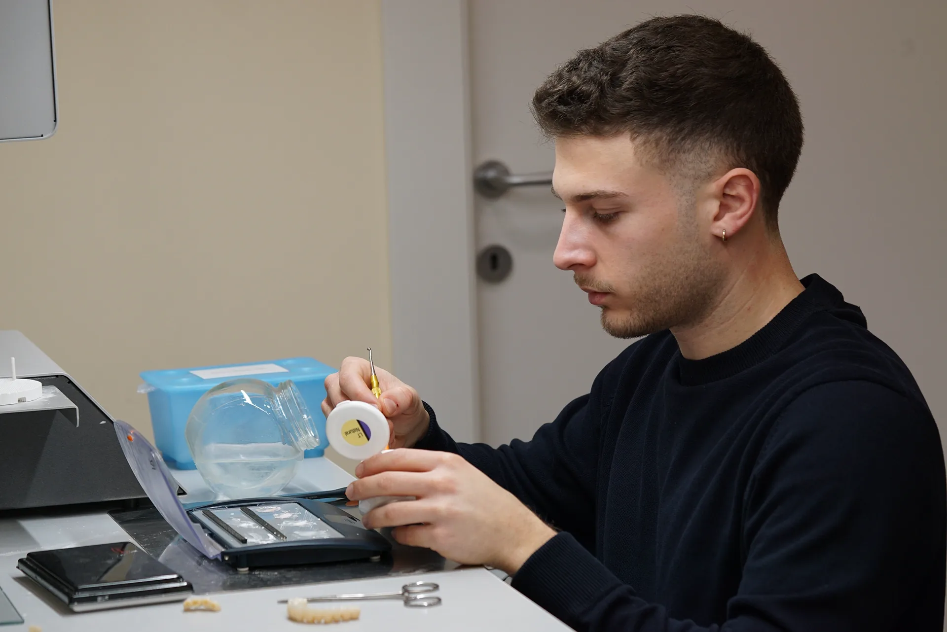 Saidu Erik al banco del laboratorio mentre caratterizza un elemento in ceramica